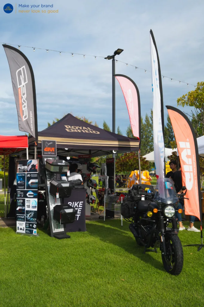เต็นท์พับ Royal Enfield และธงปีกนกหลายแบบรอบรถที่จัดแสดง