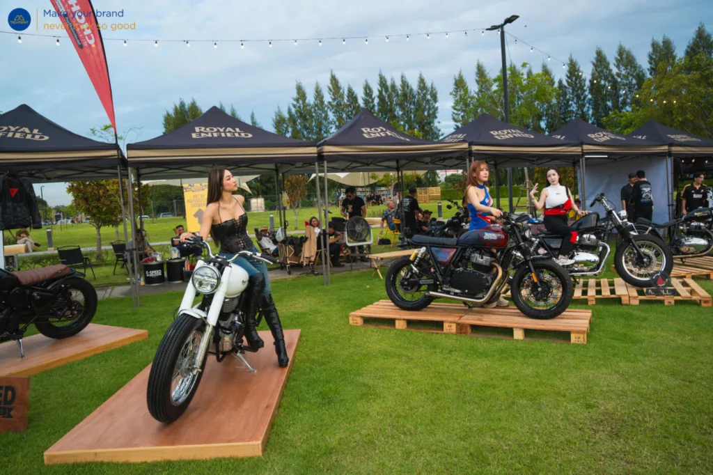 เต็นท์พับ Royal Enfield และธงปีกนกหลายแบบรอบรถที่จัดแสดง