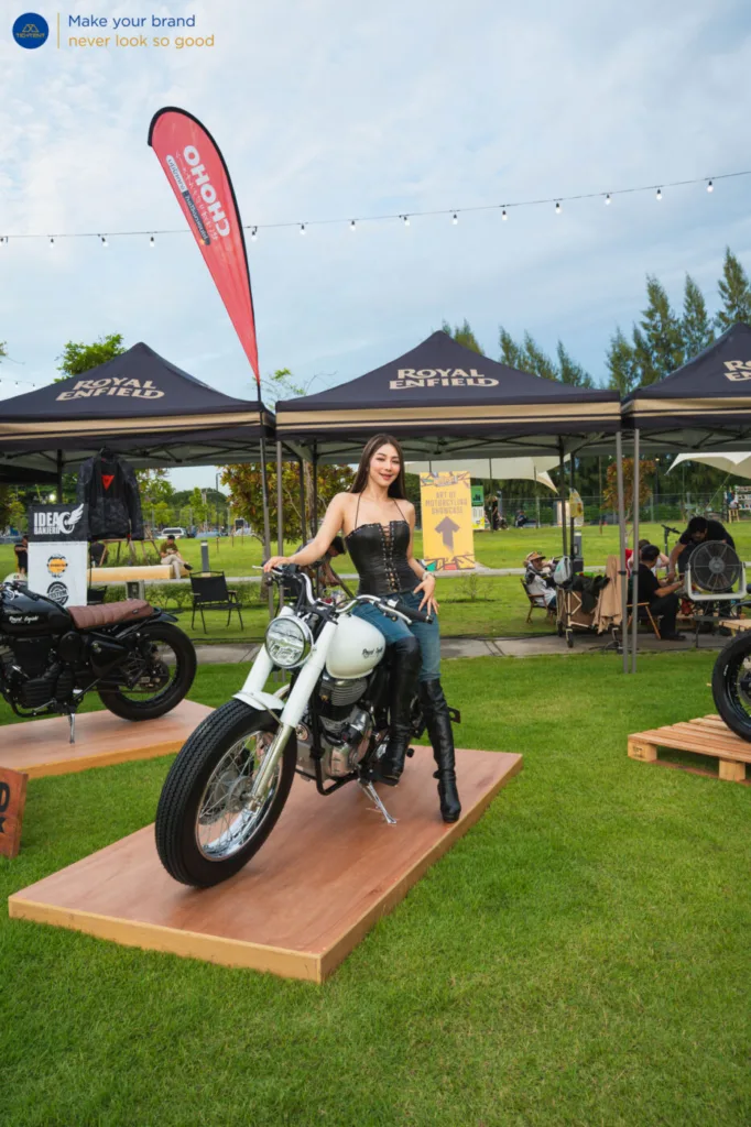 เต็นท์พับ Royal Enfield และธงปีกนกหลายแบบรอบรถที่จัดแสดง