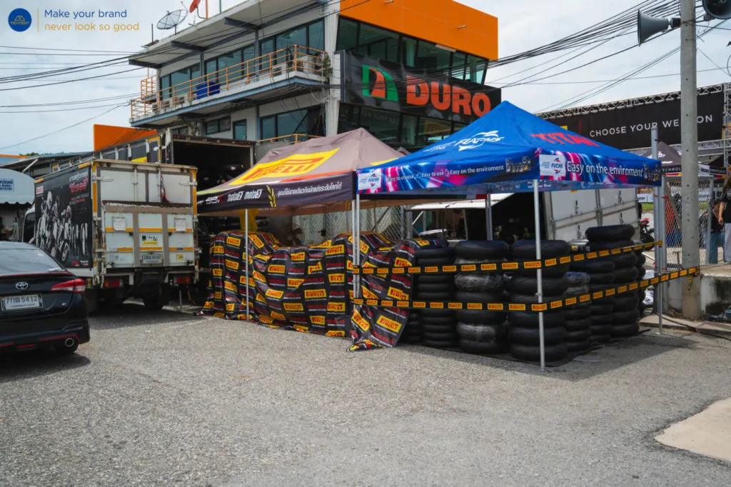 เต็นท์พับ Pirelli ในโซนบริการยาง พร้อมผ้าคลุมโต๊ะพิมพ์ลาย