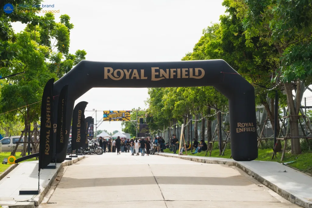 ซุ้มประตูเป่าลม Royal Enfield และธงปีกนกสีดำเรียงริมทางเข้างาน